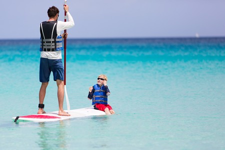 family of two enjoying stand up paddleboarding at caribbean vacation, active and healthy lifestyleの写真素材