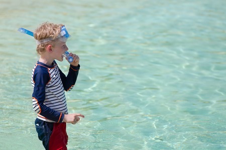 little kid ready for snorkeling at perfect caribbean beach, vacation concept with copyspaceの写真素材