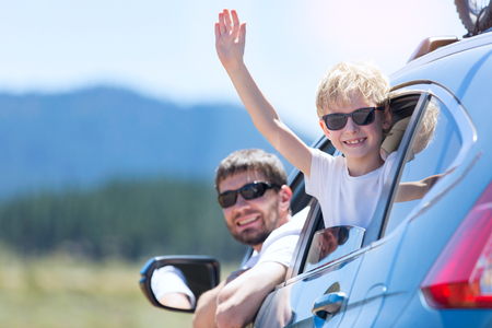 family of two smiling and looking out of the car enjoying road trip in california, vacation conceptの写真素材