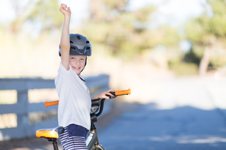 active smiling boy enjoying bike ride in the parkの写真素材