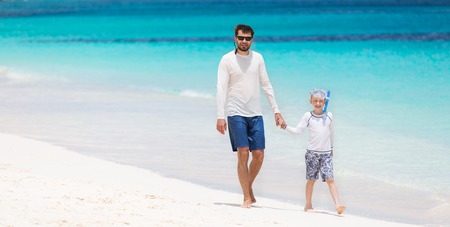 happy family of two walking at perfect caribbean white sand beach with turquoise lagoon at anguilla islandの写真素材