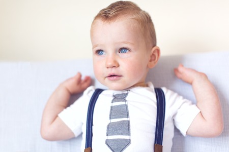 adorable toddler with blue eyes smiling and enjoying time at homeの写真素材