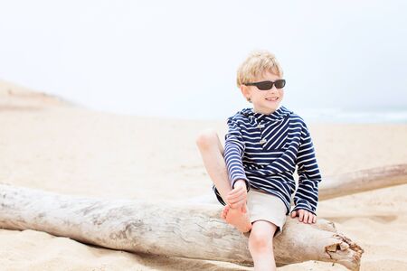 cute relaxed smiling boy in sunglasses enjoying time at the beach in californiaの写真素材