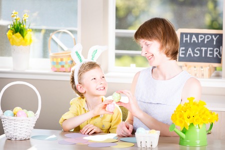 family of two, mother and her son, celebrating easter time at home with fun activities and easter egg huntの写真素材