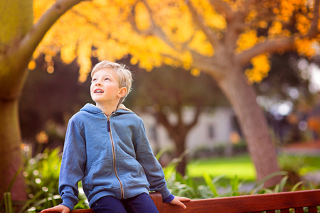 cute smiling boy being playful and positive in autumn parkの写真素材