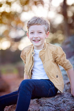 cute smiling boy being playful and positive in autumn parkの写真素材