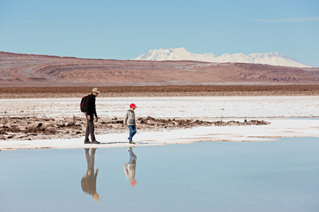 family of two, father and son, hiking and walking together enjoying salty lagunas escondidas in atacama desert, chile, healthy active family lifestyle and vacation conceptの写真素材