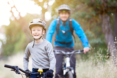family of two, young father and cheerful son, enjoying bike riding, active family conceptの写真素材