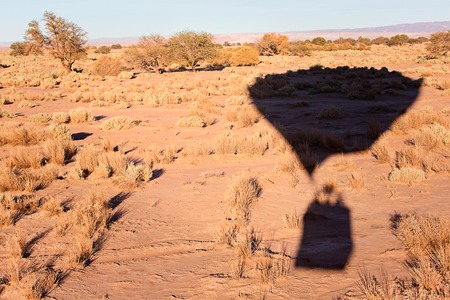 shadow on the ground of flying hot air balloon in atacama desert, chile, adventure vacation conceptの写真素材