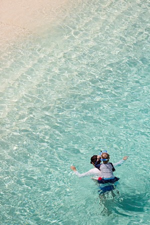 above aerial view of family of two, father and son, enjoying snorkeling in beautiful turquoise lagoon at anguilla island, caribbean, active family vacation conceptの写真素材