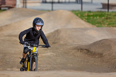 caucasian boy in full face helmet enjoying downhill mountain biking, extreme sports conceptの写真素材