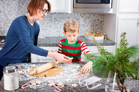 family of two, mother and her son, enjoying winter time at home and making cookies from scratch together, christmas time conceptの写真素材