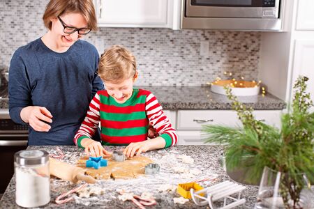 family of two, mother and son, making gingerbread cookies and having fun at home during christmas time, holiday conceptの写真素材