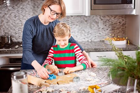 family of two, mother and son, making gingerbread cookies and having fun at home during christmas time, holiday conceptの写真素材