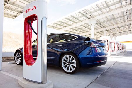 Kettleman City, CA - April 28, 2019: newest navy tesla model 3 charging at supercharger stationのeditorial素材