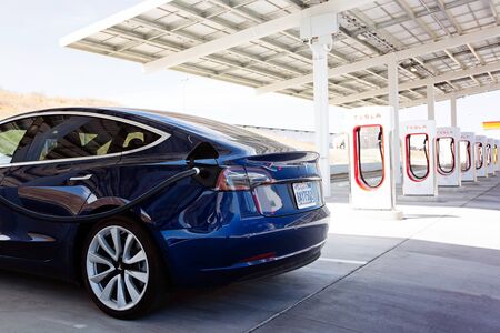 Kettleman City, CA - April 28, 2019: newest navy tesla model 3 charging at supercharger stationのeditorial素材