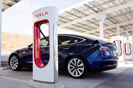 Kettleman City, CA - April 28, 2019: newest navy tesla model 3 charging at supercharger stationのeditorial素材
