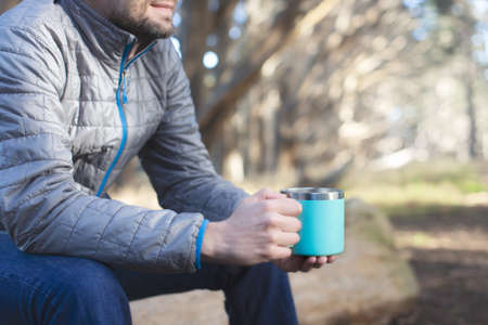 positive man outdoor enjoying his drink out of reusable cup, environmentally friendly option, zero waste conceptの写真素材