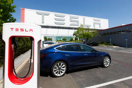 Fremont, CA - May 1, 2020: Tesla model 3 charging at supercharger station at Tesla factory in Fremont during plant closure due to coronavirus (covid-19) pandemic, the only Tesla factory in USAのeditorial素材