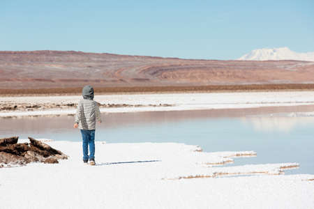 back view of little boy hiking and enjoying salty lagunas escondidas in atacama desert, chile, healthy active family lifestyle and vacation concept, copy space on rightの写真素材