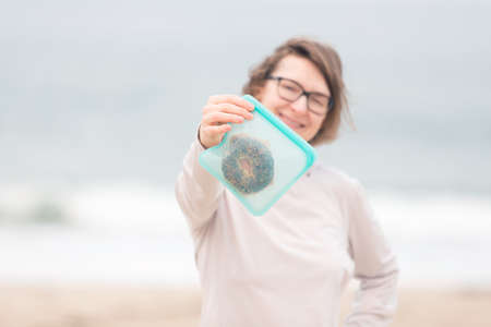woman holding silicone reusable snack bag with food inside, zero waste concept, aqua menthe is year 2020 trend colorの写真素材