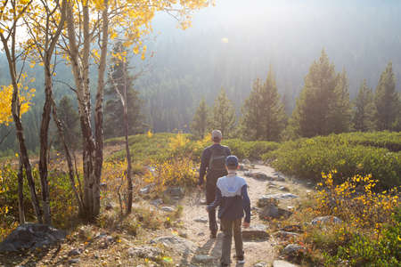 family of two, father and son, hiking and enjoying the gorgeous views in grand teton national parl, wyoming, during fall, active family vacation conceptの写真素材