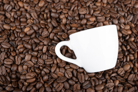 Coffee beans and white coffee cup on a white background.