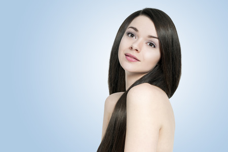 Beautiful young brunette woman with long shiny hairの写真素材