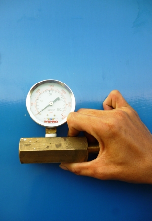 One hand holds a male part of a regulator and wrench It is isolated on a blue background 