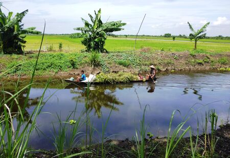 a father and his two children along a river in Indonesiaのeditorial素材