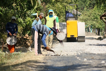 Men on an asphalt paver repairing a roadのeditorial素材