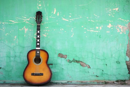 Guitar leaned to a blue wallの写真素材