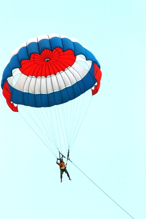 man is parasailing over the  sea in tanjung benoa beachの写真素材