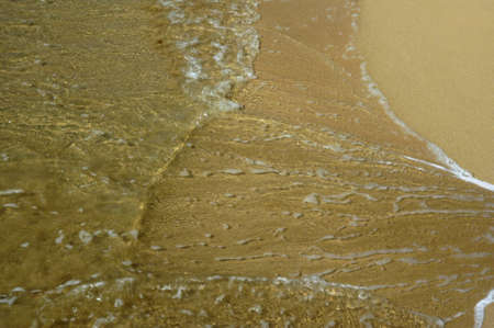 Sea wave breaking against sand beach for background