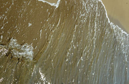 Sea wave breaking against sand beach for background
