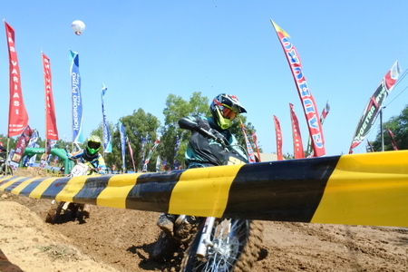 Motocross racer accelerating in dust trackのeditorial素材