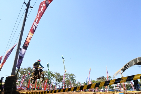 Motocross racer accelerating in dust trackのeditorial素材