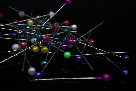 dozens of colorful needles on dark backgroundの写真素材