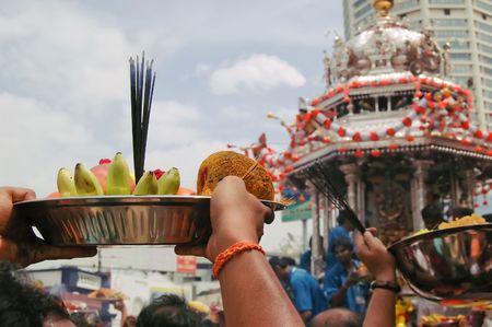 A devotee offers fruits and sweets to the oncoming chariot of Murugan during the yearly festival of Thaipusam in Penang, Malaysia.のeditorial素材