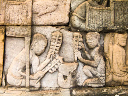 Relief in the walls of the Bayon depicting two men cooking over a stove-pot.の写真素材