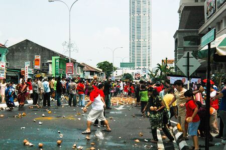 Penang, Malaysia, 2 Feb 2009. Devotees smashing coconuts in the street in anticipation of the arrival of Lord Murugan's chariot in the annual Thaipusam festival.のeditorial素材