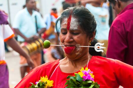 20 January 2011, Kuala Lumpur, Malaysia: A female Hindu devotee is skewered through the cheeks during the annual Thaipusam festival.のeditorial素材