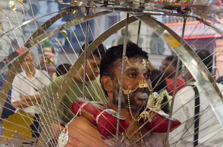 Singapore, Singapore - 7 February 2012: A man carries and is skewered by the ceremonial kavadi, a decorated metal frame, as part of a thanksgiving ritual at the annual Thaipusam festival.のeditorial素材