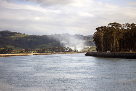 a landscape with smoke in a magnificent scenary of a estuaryの写真素材