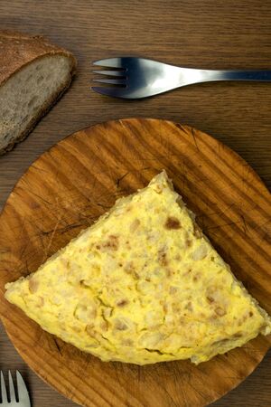 a traditional spanish tapa of spanish omelet with bread and a forkの写真素材