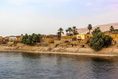 a horizontal view of a little village at he banks of the Nile riverの写真素材