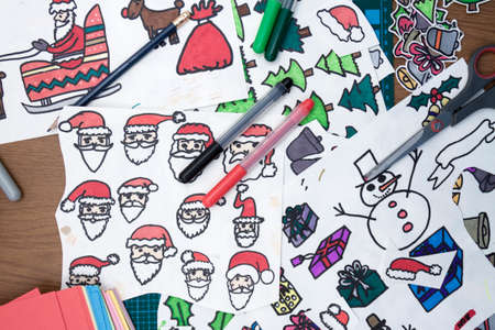 a horizontal overhead view of some xmas drawings and some of the materials used