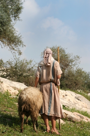 A shepherd in traditional dress leads a ram through the hills of Galilee, Israel A shepherd in traditional dress leads a ram through the hills of Galilee, Israel