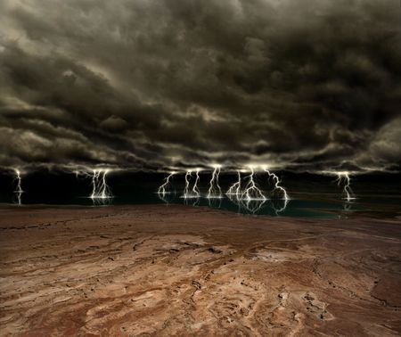 Lightning and ominous clouds over a desert plain and distant lake