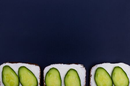 Sandwich with cucumber on slice of bread. Concept of healthy eating, lunch menu, dinner, snack. Sandwich vegetables on black, background, copy space.の写真素材